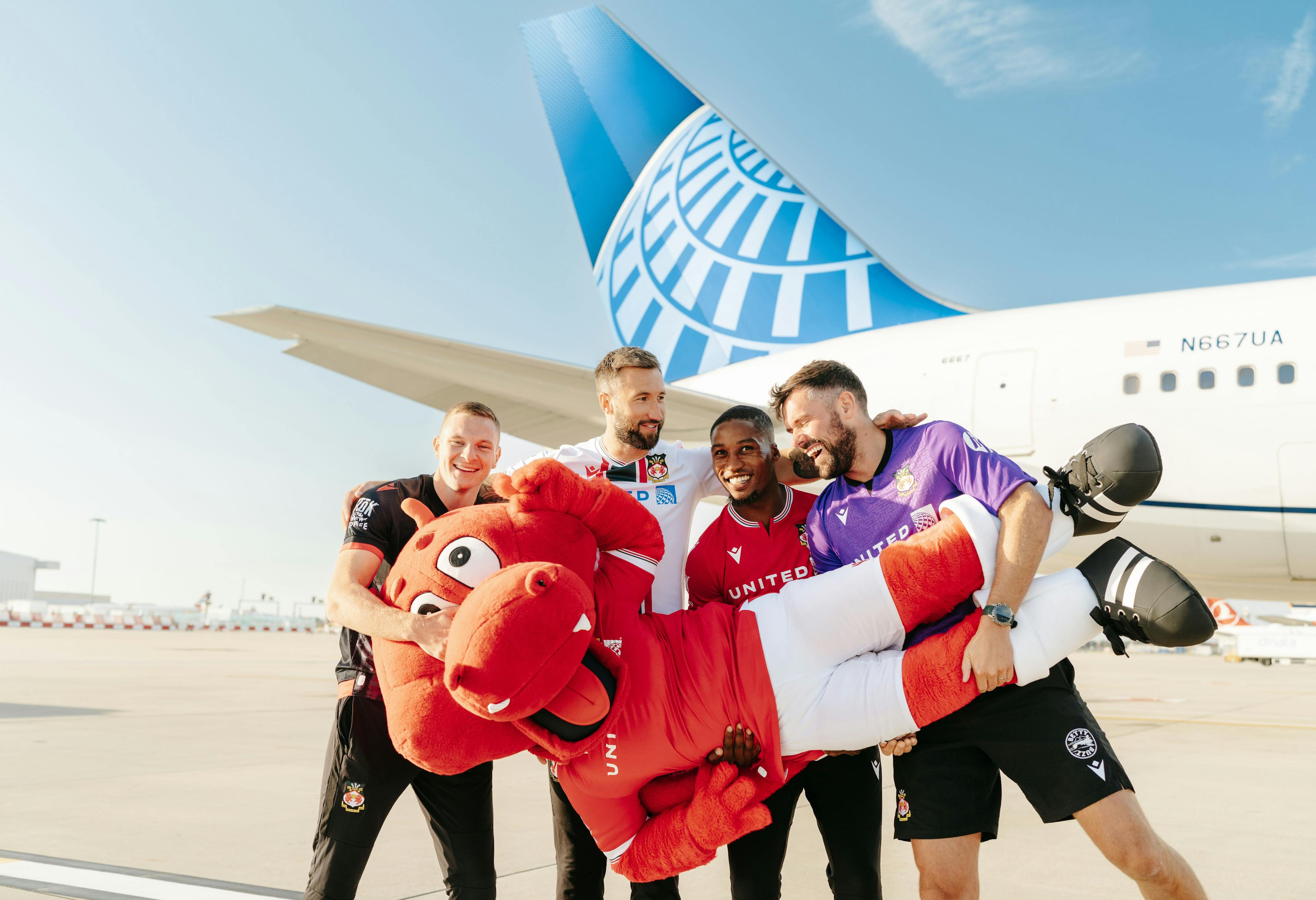 Wrexham players with mascot in front of United plane