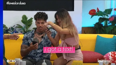 a gif of a Love Island USA contestant with the phrase 'i got a text'